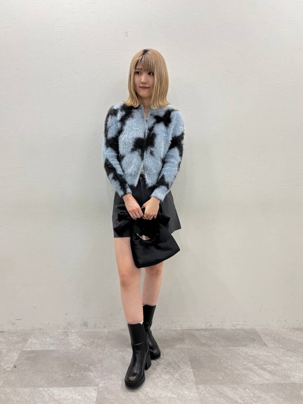 グレー系のその他パンツ、ブラック系のハンドバッグ、ブラック系のブーツを着用したレディースの冬コーディネートの2枚目の写真