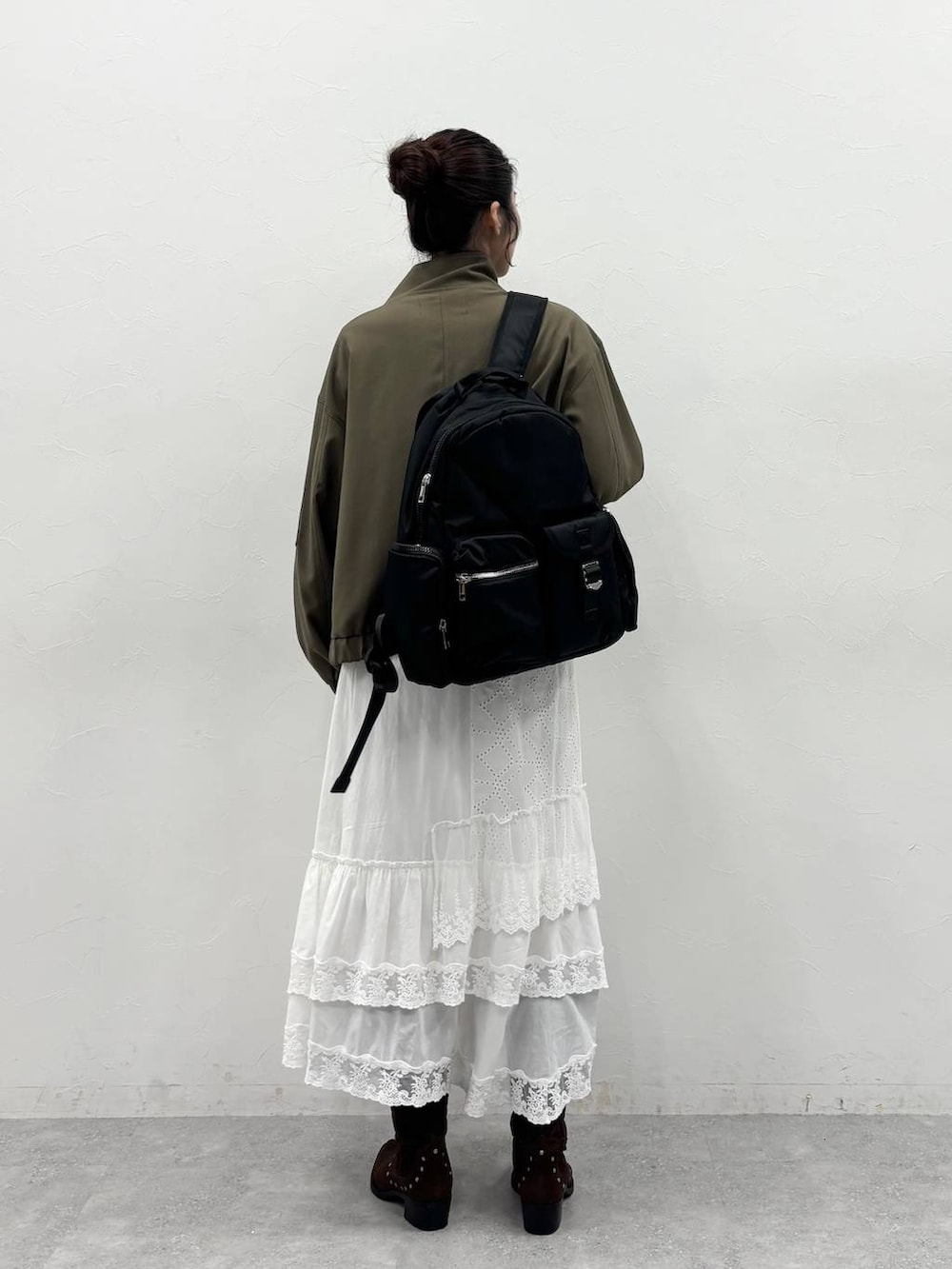 ブラウン系のブーツ、ブラック系のバックパック/リュック、グリーン系のブルゾンを着用したレディースの冬コーディネートの4枚目の写真