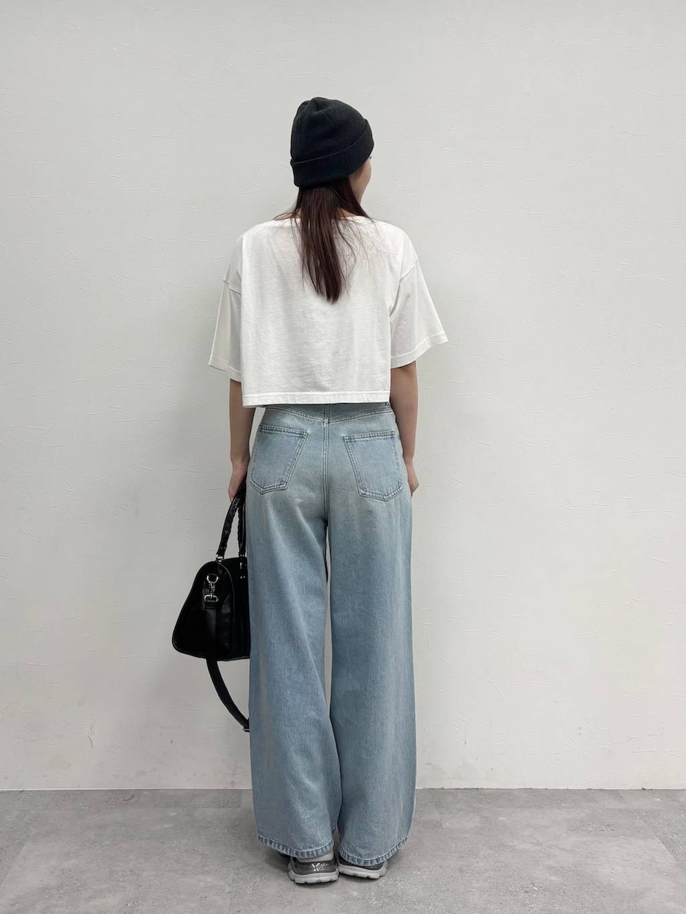 シルバー系のローファー、ブラック系のボストンバッグ、ホワイト系のTシャツ/カットソーを着用したレディースの春コーディネートの4枚目の写真