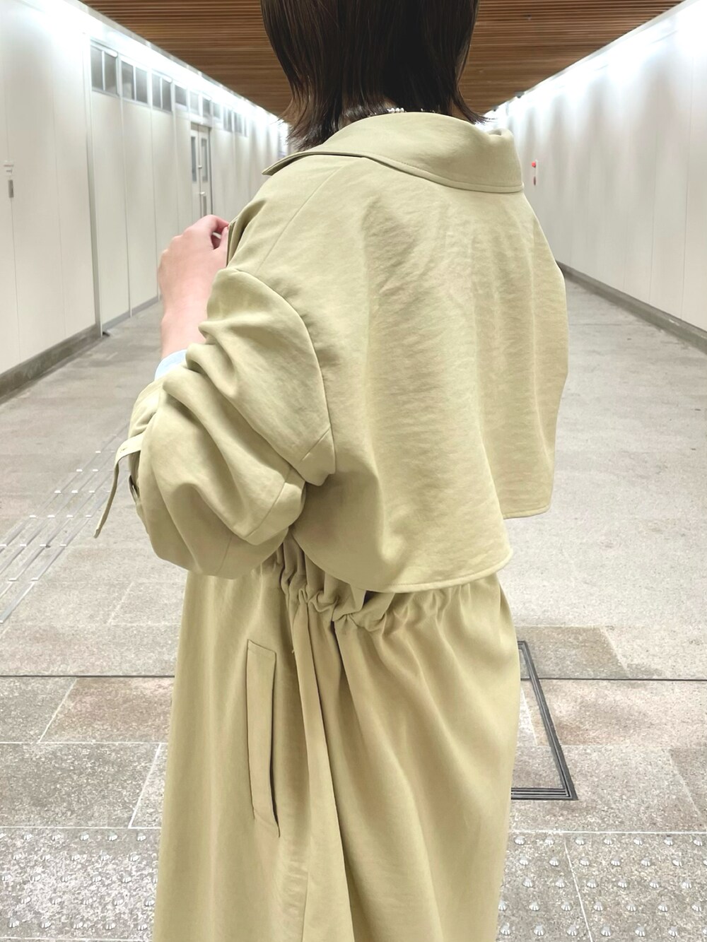 ベージュ系のトレンチコート、グレー系のスウェット、ホワイト系のTシャツ/カットソーを着用したレディースの冬コーディネートの5枚目の写真