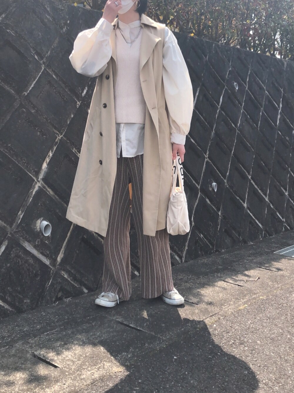 ホワイト系のベスト、ブラウン系のその他パンツ、ホワイト系のトートバッグを着用したレディースの春コーディネートの2枚目の写真