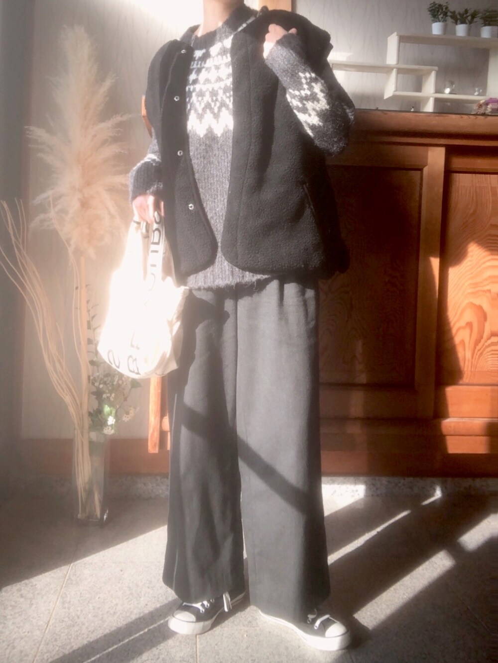 グレー系のニット/セーター、ブラック系のブルゾン、ブラック系のスニーカーを着用したレディースの秋コーディネートの2枚目の写真