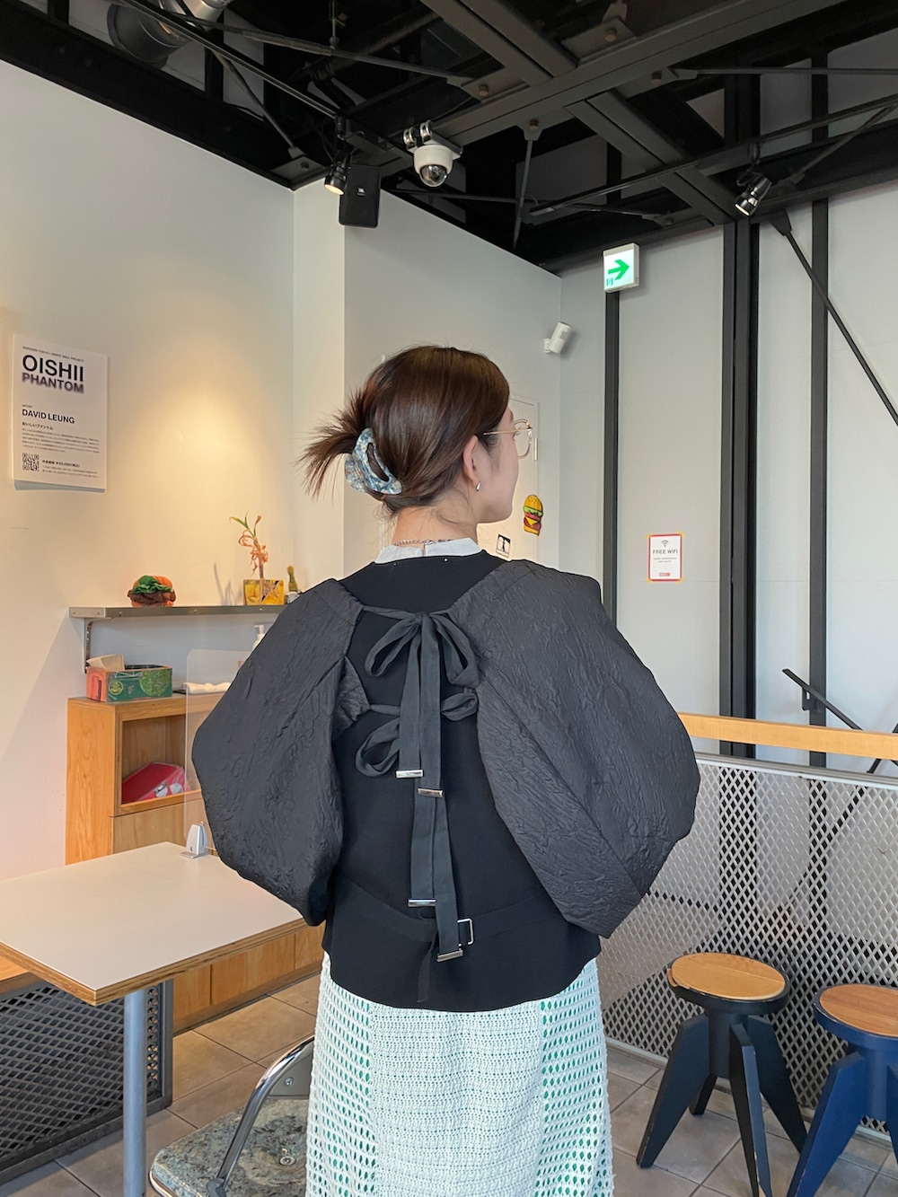 ブラック系のカーディガン/ボレロ、ホワイト系のワンピース/ドレス、グリーン系のショルダーバッグを着用したレディースの冬コーディネートの2枚目の写真