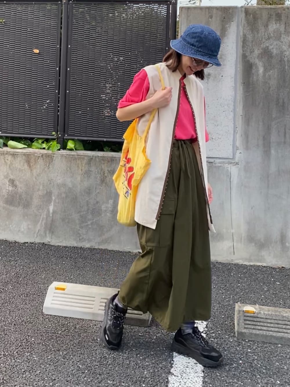 ピンク系のTシャツ/カットソー、グリーン系のスカート、ブラック系のスニーカーを着用したレディースの春コーディネートの2枚目の写真