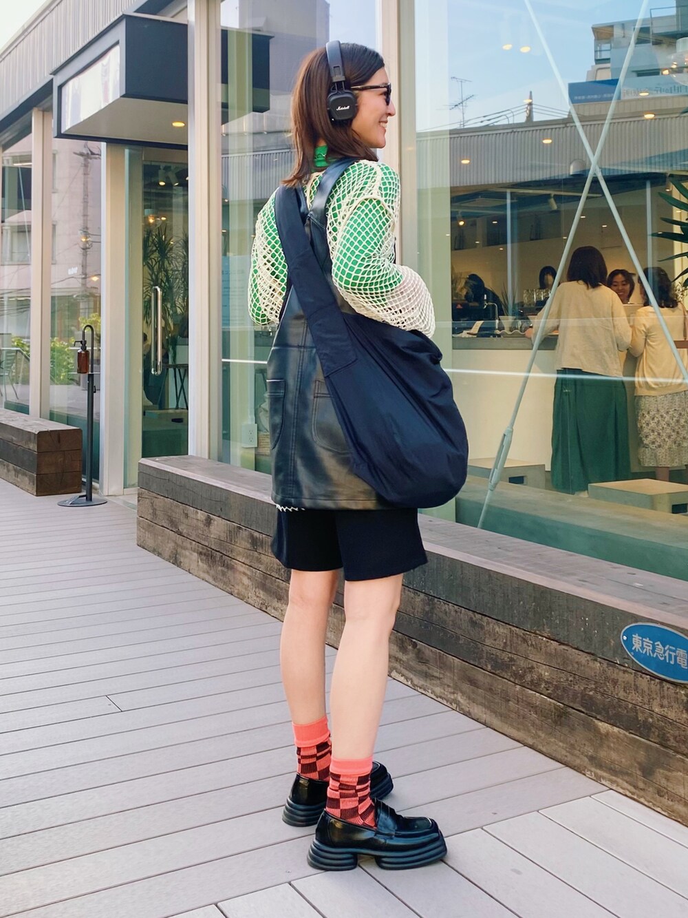 ブラック系のサロペット/オーバーオール、ベージュ系のTシャツ/カットソー、グリーン系のTシャツ/カットソーを着用したレディースの春コーディネートの4枚目の写真