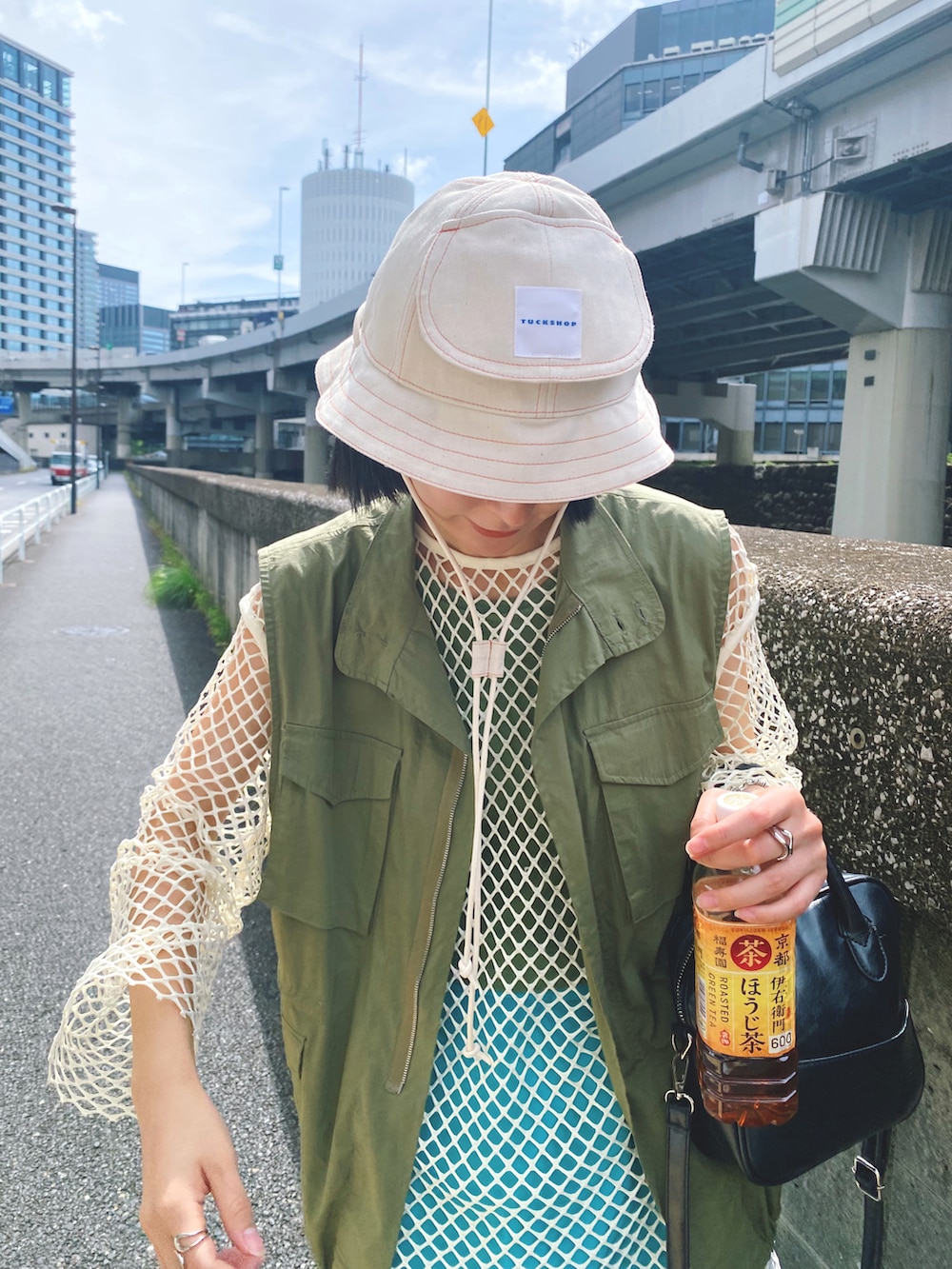 ベージュ系のTシャツ/カットソー、グリーン系のベスト、ブラック系のショルダーバッグを着用したレディースの秋コーディネートの3枚目の写真