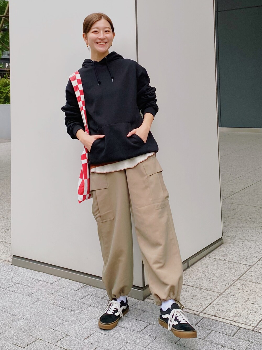 ブラック系のパーカー、グリーン系のカーゴパンツ、ブラック系のスニーカーを着用したレディースの秋コーディネートの2枚目の写真