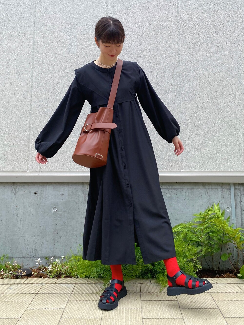 ブラック系のサンダル、ブラック系のシャツワンピース、ブラウン系のバッグを着用したレディースの夏コーディネートの3枚目の写真