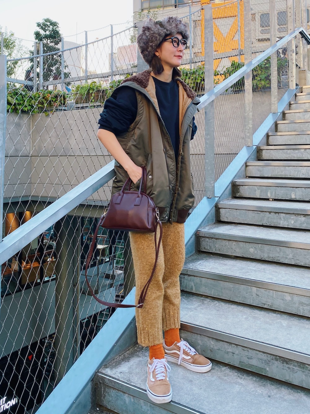 グリーン系のブルゾン、ブラック系のスウェット、ベージュ系のパンツを着用したレディースの秋コーディネートの3枚目の写真