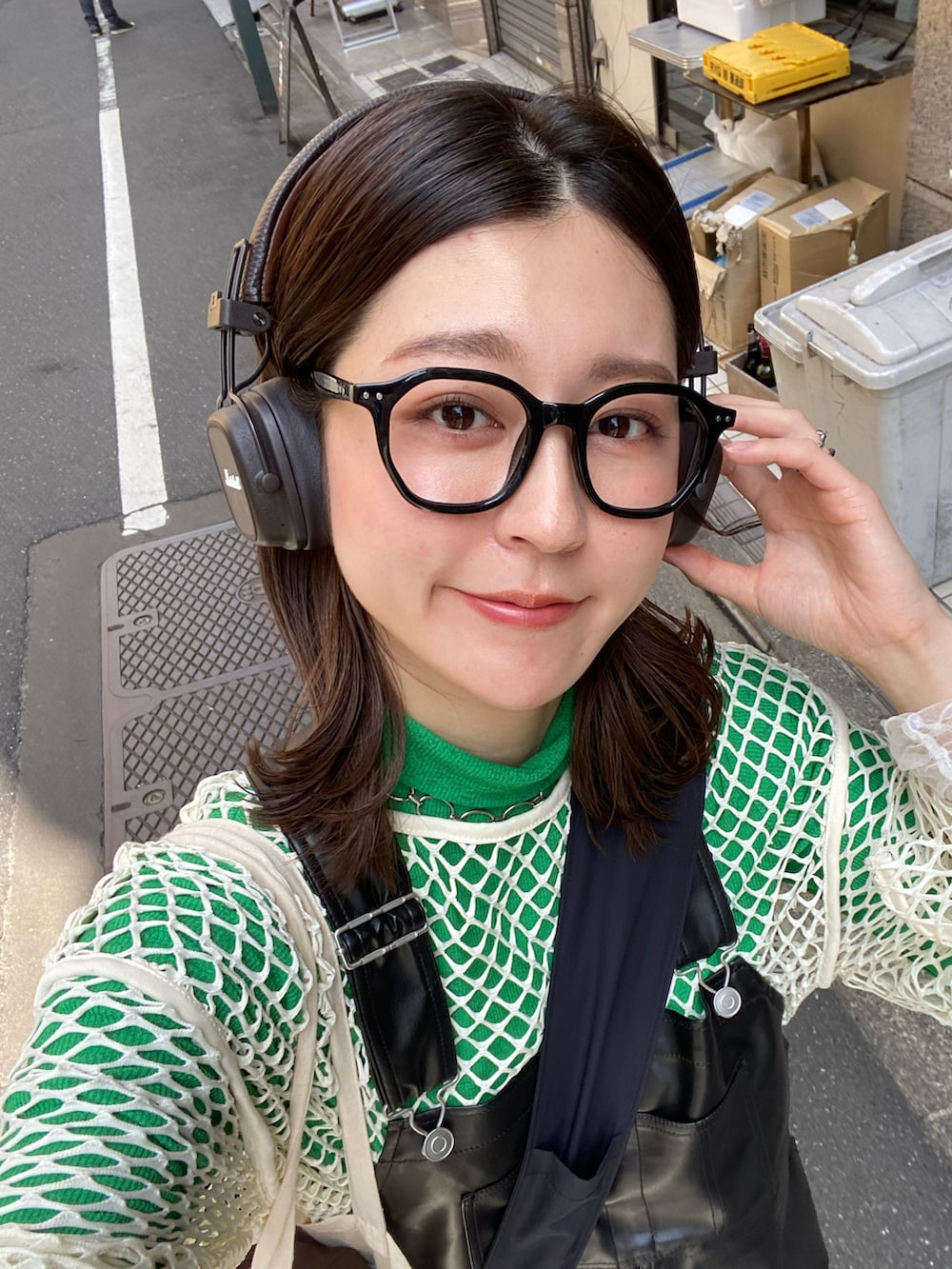 ブラック系のサロペット/オーバーオール、ベージュ系のTシャツ/カットソー、グリーン系のTシャツ/カットソーを着用したレディースの春コーディネートの2枚目の写真