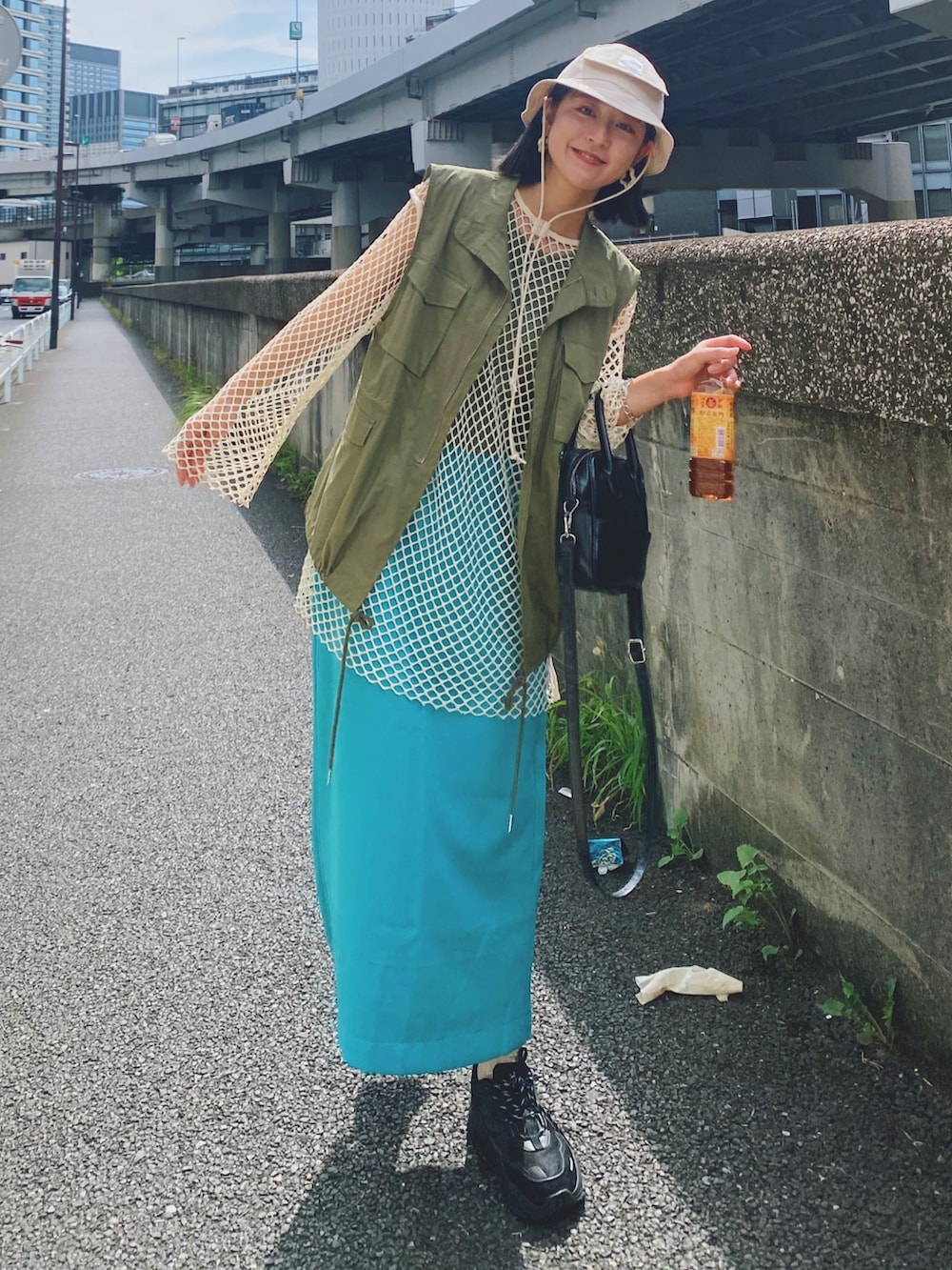 ベージュ系のTシャツ/カットソー、グリーン系のベスト、ブラック系のショルダーバッグを着用したレディースの秋コーディネートの2枚目の写真