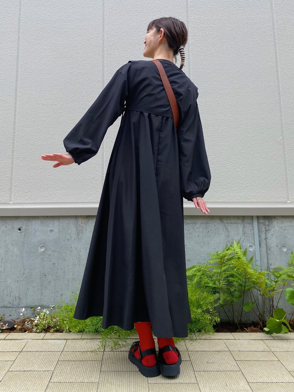 ブラック系のサンダル、ブラック系のシャツワンピース、ブラウン系のバッグを着用したレディースの夏コーディネートの2枚目の写真