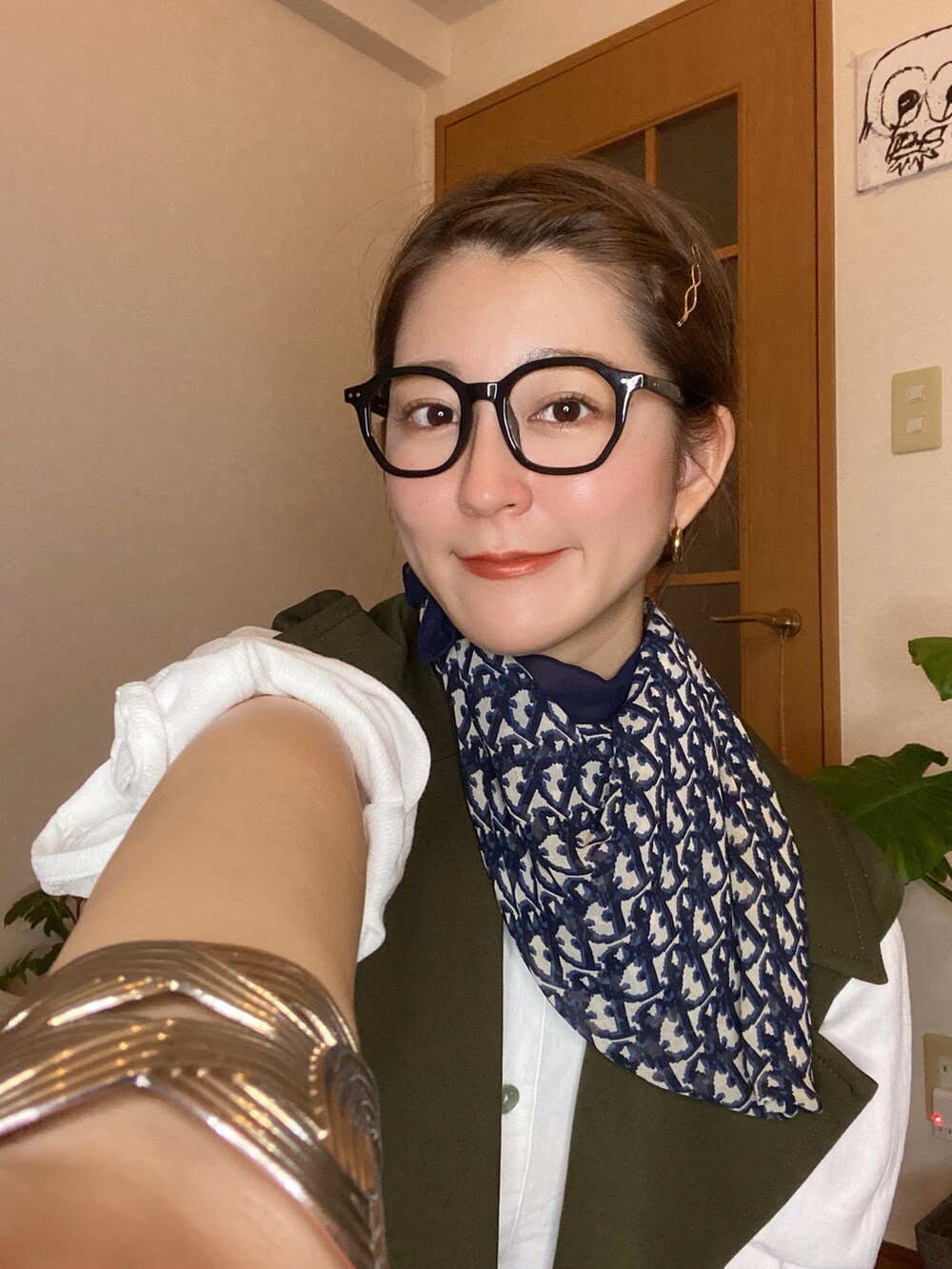 グリーン系のトレンチコート、ブラック系のショルダーバッグ、ブラック系のローファーを着用したレディースの秋コーディネートの2枚目の写真