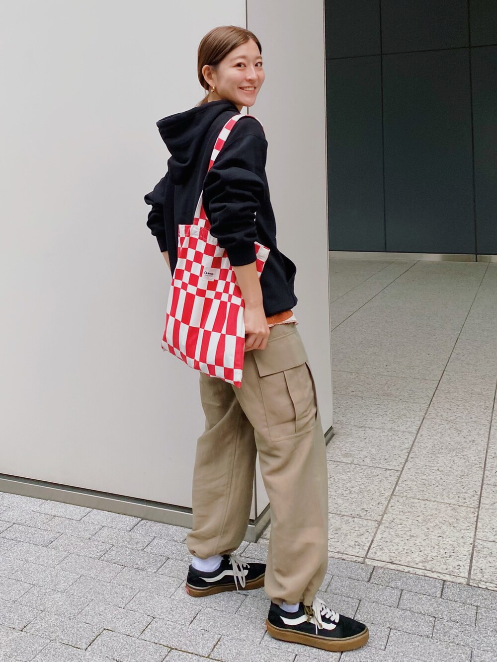 ブラック系のパーカー、グリーン系のカーゴパンツ、ブラック系のスニーカーを着用したレディースの秋コーディネートの4枚目の写真