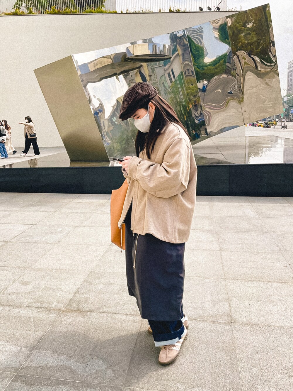 ベージュ系のスーツジャケット、ブラック系のスーツジャケット、ブルー系のデニムパンツを着用したレディースの冬コーディネートの2枚目の写真