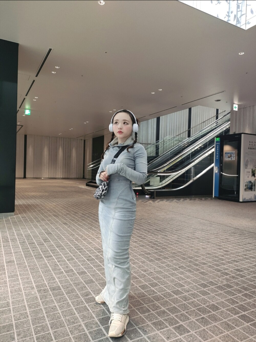 ブルー系のワンピース、ベージュ系のスニーカーを着用したレディースの春コーディネートの2枚目の写真
