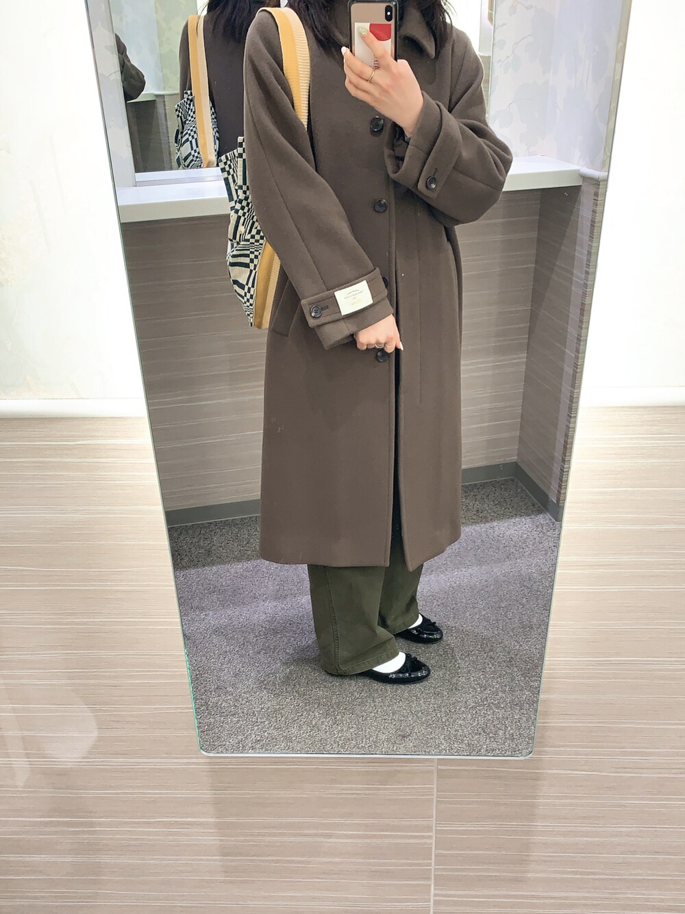 グリーン系のサロペット/オーバーオール、ブラウン系のステンカラーコートを着用したレディースの冬コーディネートの2枚目の写真