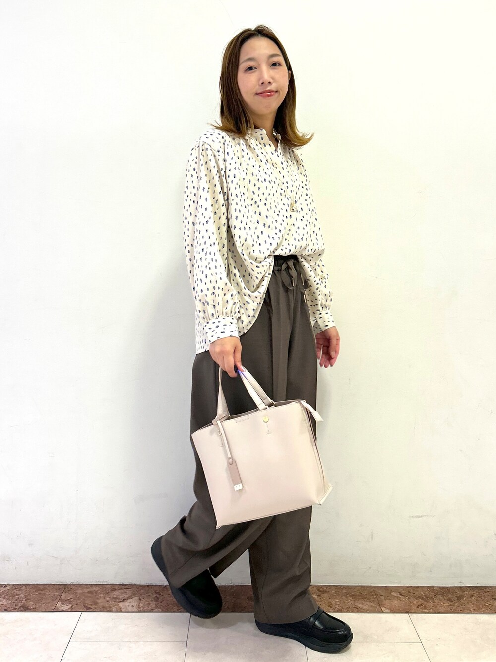 ベージュ系のシャツ/ブラウス、ブラウン系のその他パンツ、ベージュ系のトートバッグを着用したレディースの秋コーディネートの6枚目の写真