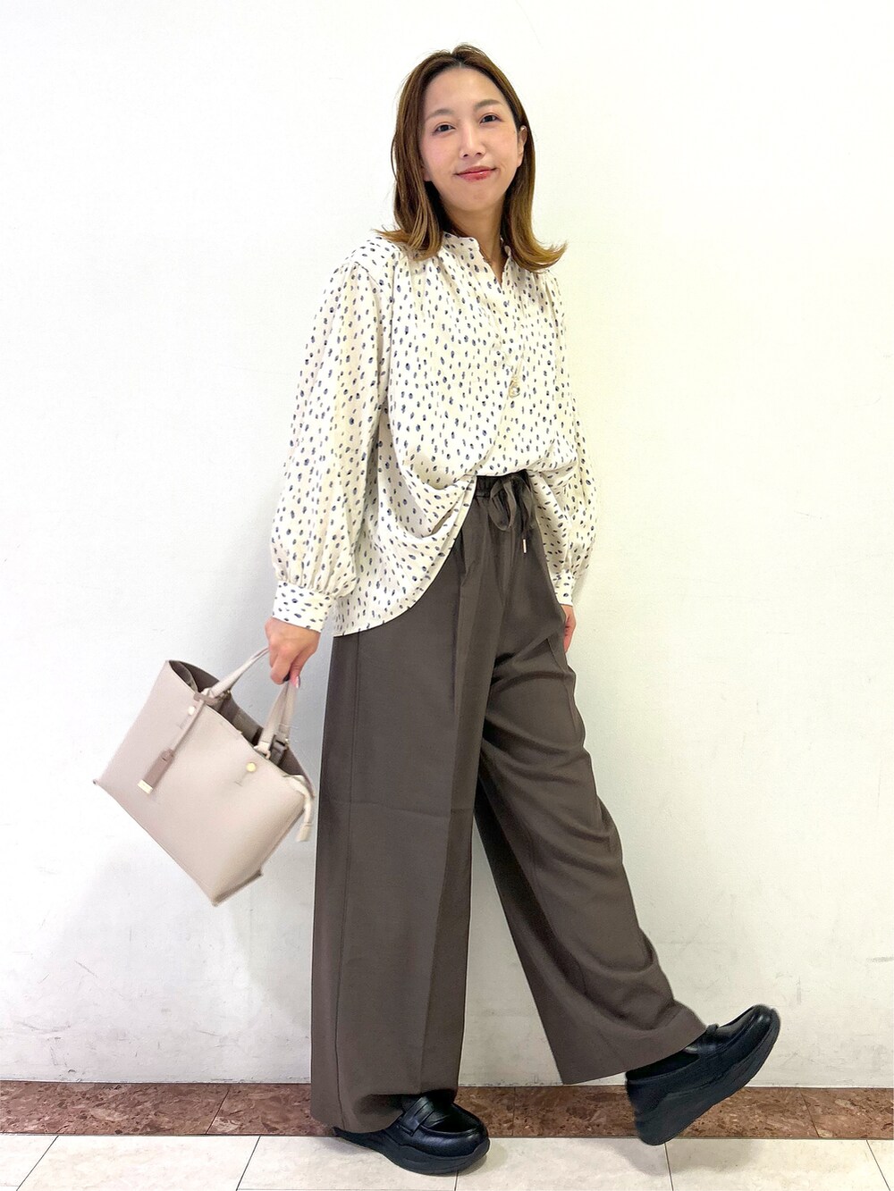 ベージュ系のシャツ/ブラウス、ブラウン系のその他パンツ、ベージュ系のトートバッグを着用したレディースの秋コーディネートの7枚目の写真