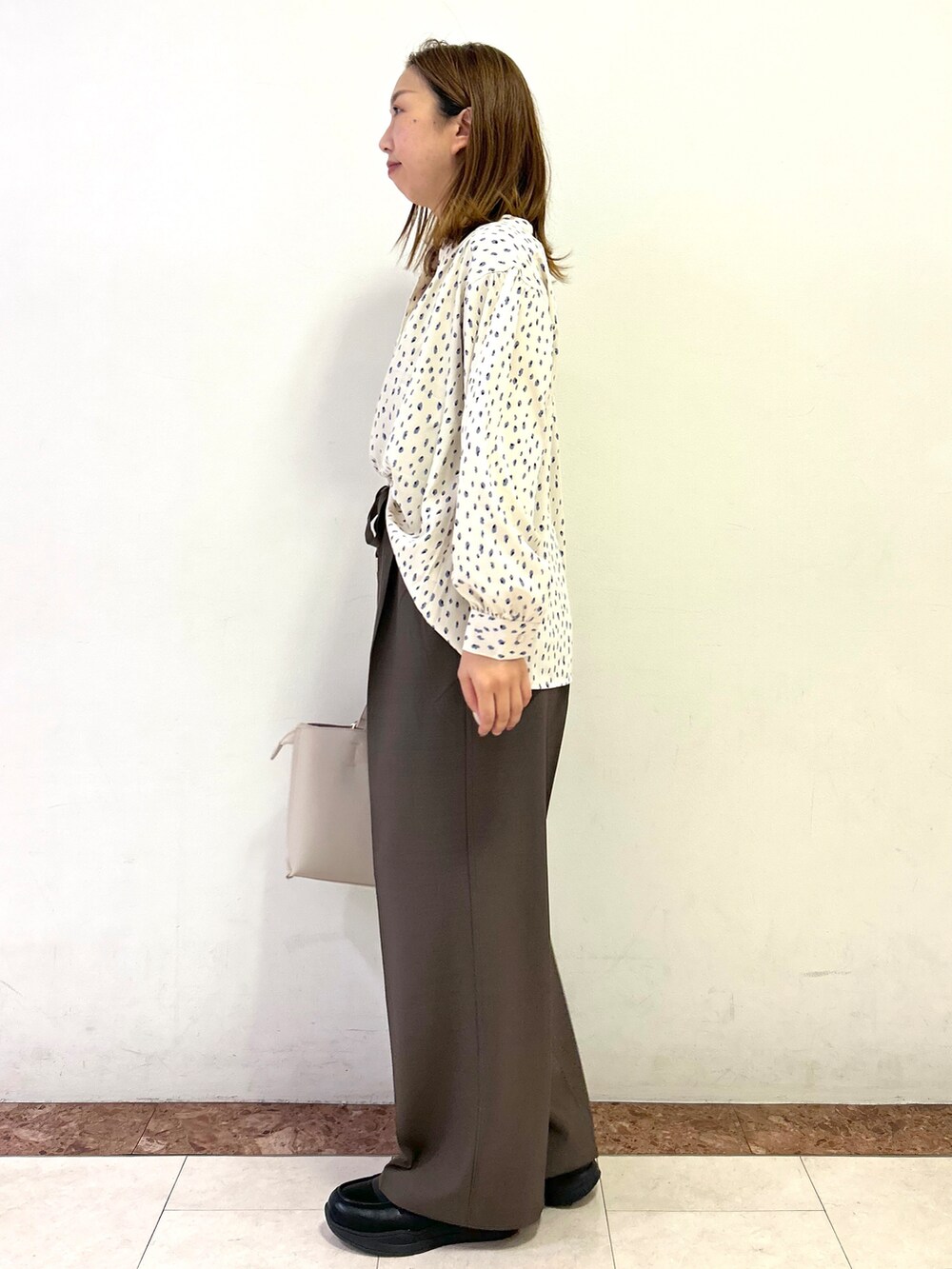 ベージュ系のシャツ/ブラウス、ブラウン系のその他パンツ、ベージュ系のトートバッグを着用したレディースの秋コーディネートの3枚目の写真