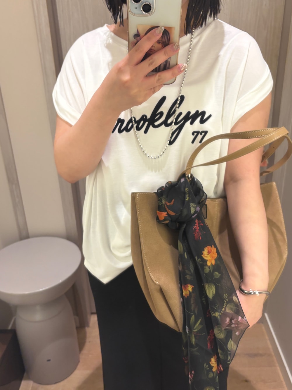 ホワイト系のTシャツ/カットソー、ブラック系のスカート、ベージュ系のサンダルを着用したレディースの夏コーディネートの2枚目の写真
