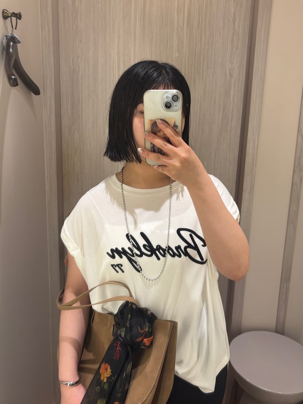 ホワイト系のTシャツ/カットソー、ブラック系のスカート、ベージュ系のサンダルを着用したレディースの夏コーディネートの3枚目の写真