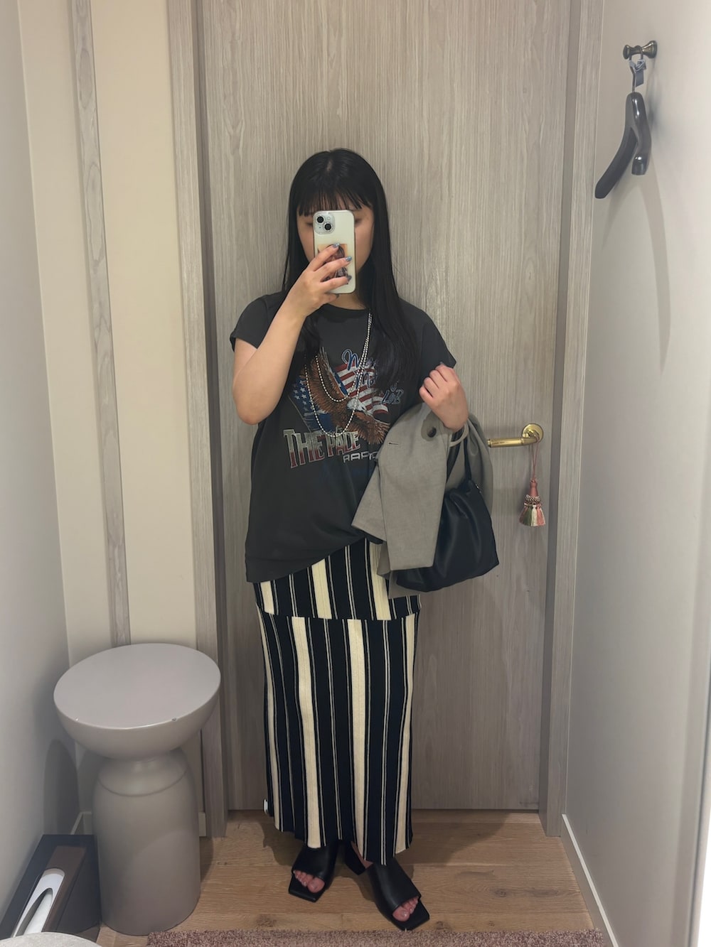 ブラック系のスカート、ブラック系のサンダル、ブラック系のTシャツ/カットソーを着用したレディースの夏コーディネートの2枚目の写真