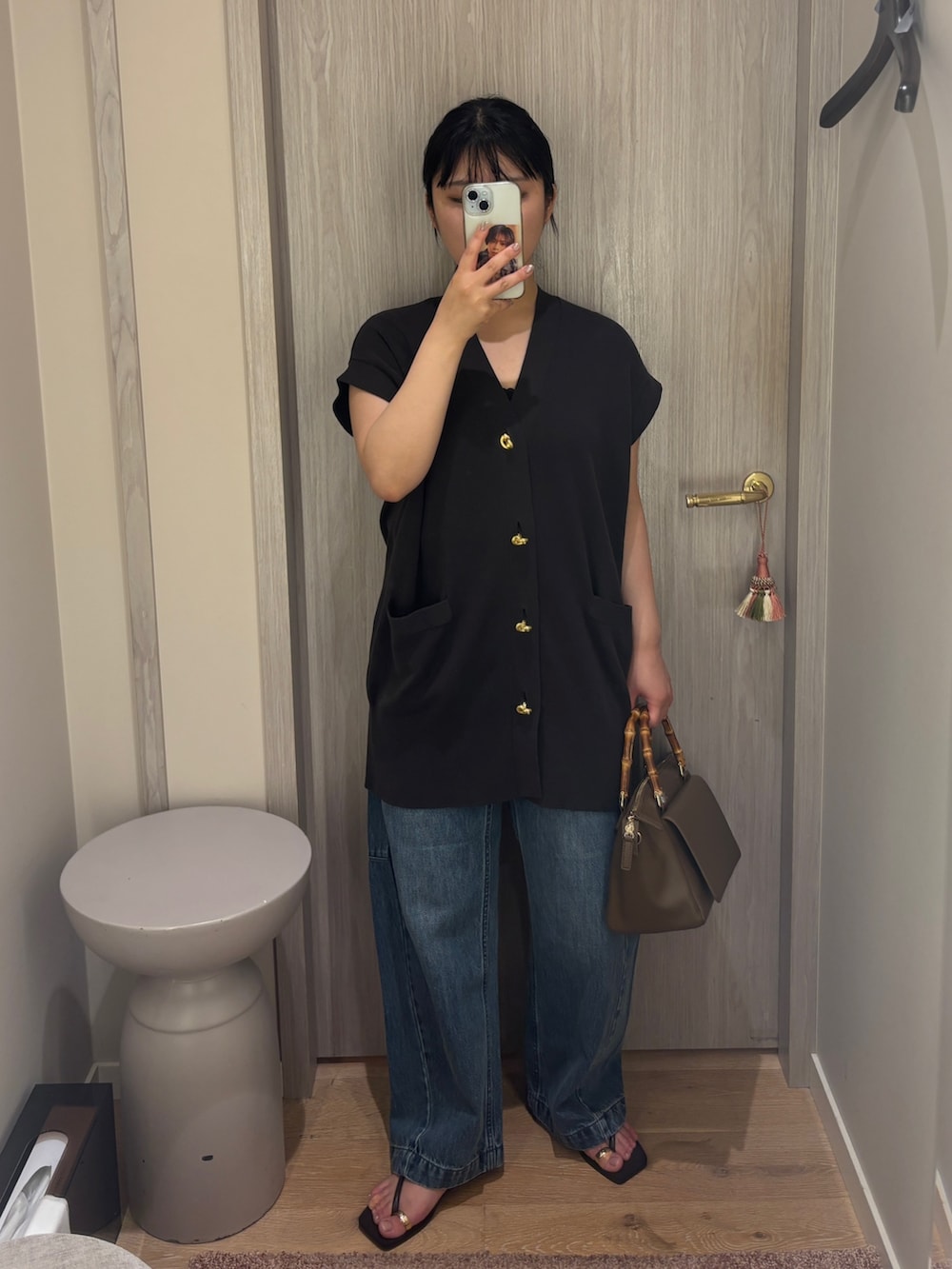 ブラウン系のカーディガン/ボレロ、ブルー系のデニムパンツ、ゴールド系のサンダルを着用したレディースの夏コーディネートの2枚目の写真