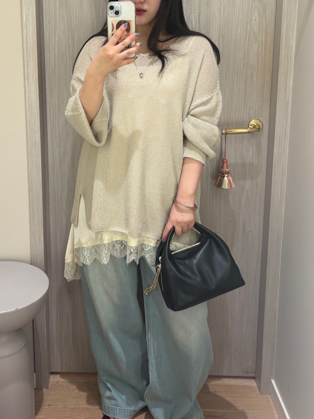 ホワイト系のキャミソール、ブルー系のデニムパンツ、ブラック系のサンダルを着用したレディースの夏コーディネートの2枚目の写真