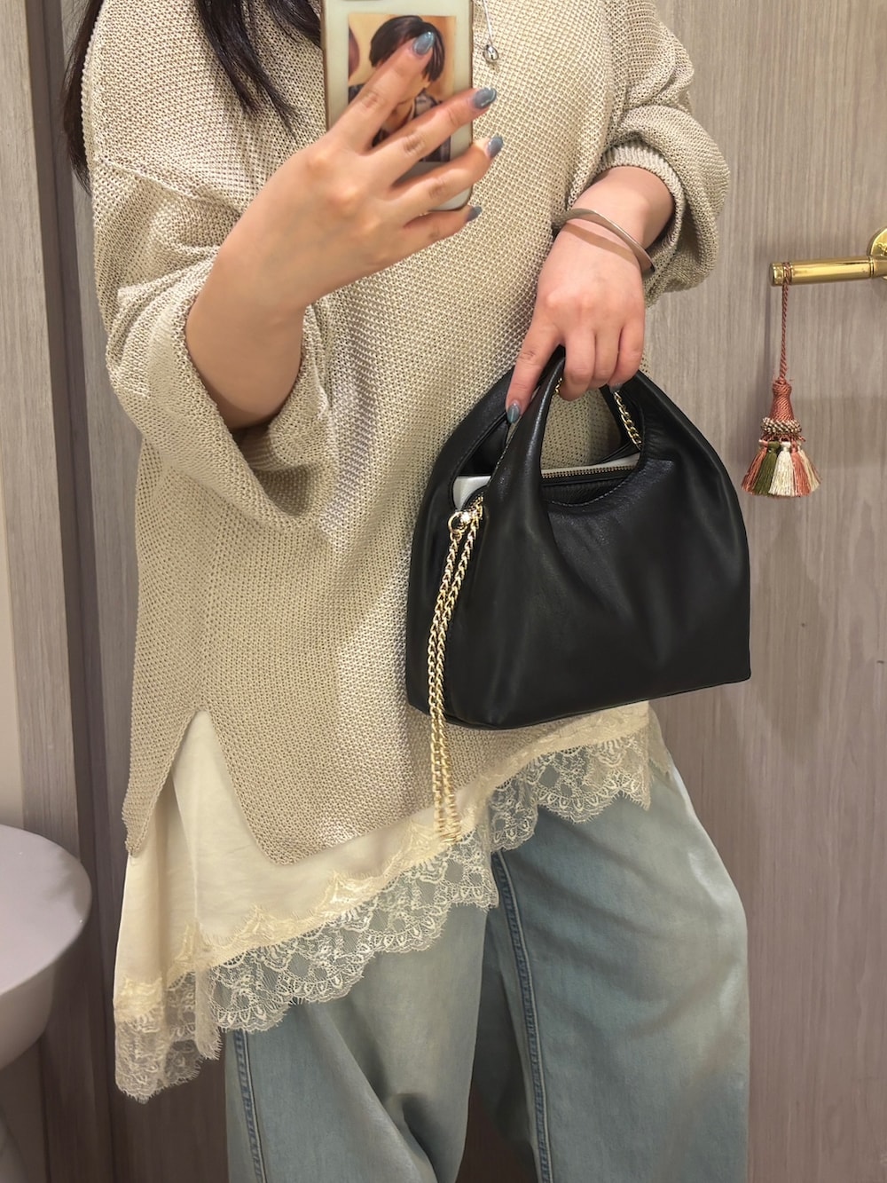 ホワイト系のキャミソール、ブルー系のデニムパンツ、ブラック系のサンダルを着用したレディースの夏コーディネートの3枚目の写真