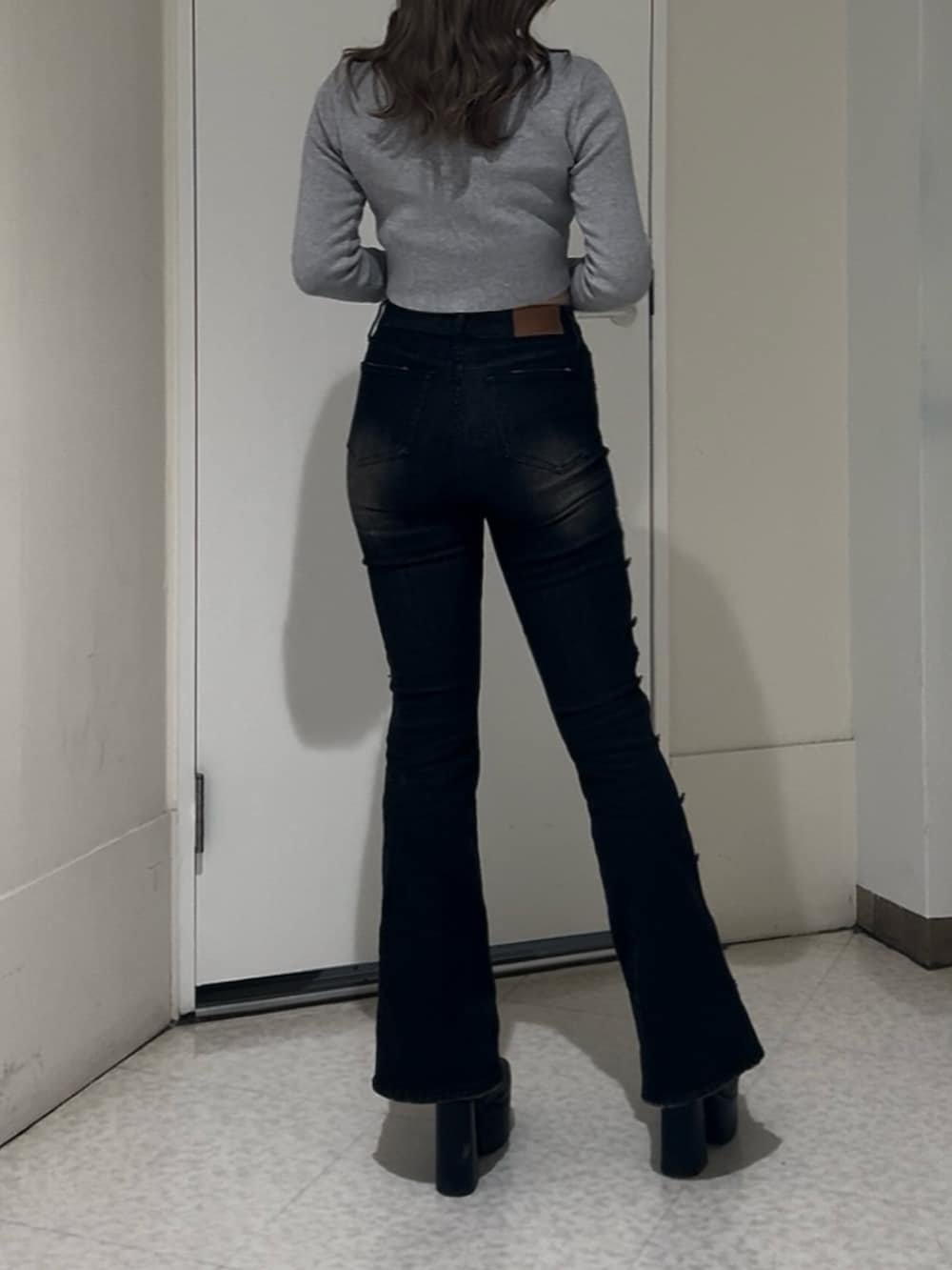 ブラック系のニット/セーター、ブラック系のデニムパンツ、ブラック系のブーツを着用したレディースの冬コーディネートの3枚目の写真