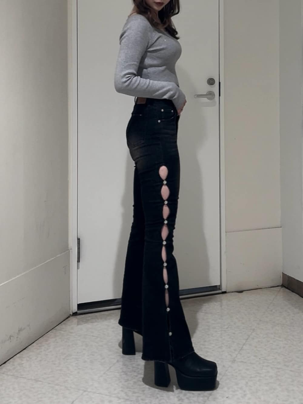 ブラック系のニット/セーター、ブラック系のデニムパンツ、ブラック系のブーツを着用したレディースの冬コーディネートの2枚目の写真