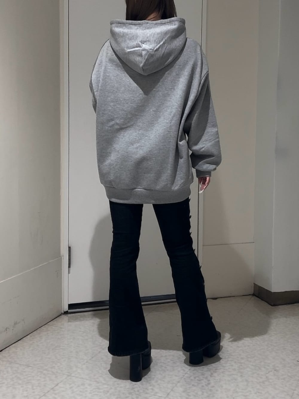 ブラック系のブーツ、グレー系のスウェット、ブラック系のデニムパンツを着用したレディースの冬コーディネートの3枚目の写真