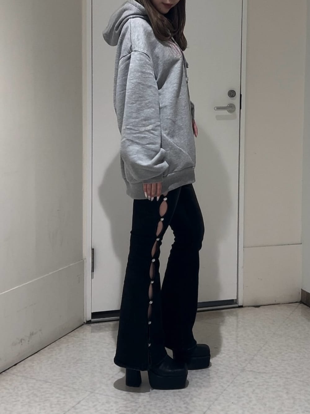 ブラック系のブーツ、グレー系のスウェット、ブラック系のデニムパンツを着用したレディースの冬コーディネートの2枚目の写真