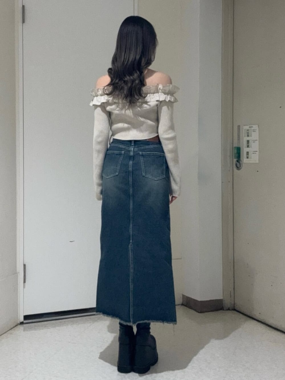 ブラック系のブーツ、ベージュ系のニット/セーター、ブルー系のデニムスカートを着用したレディースの春コーディネートの3枚目の写真