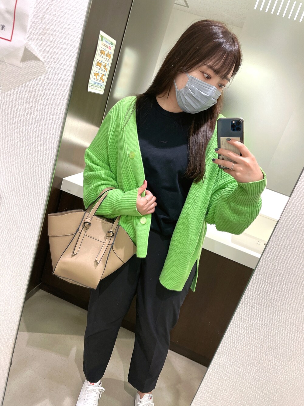ブラウン系のトートバッグ、ブラック系のTシャツ/カットソー、ブラック系のパンツを着用したレディースの春コーディネートの2枚目の写真