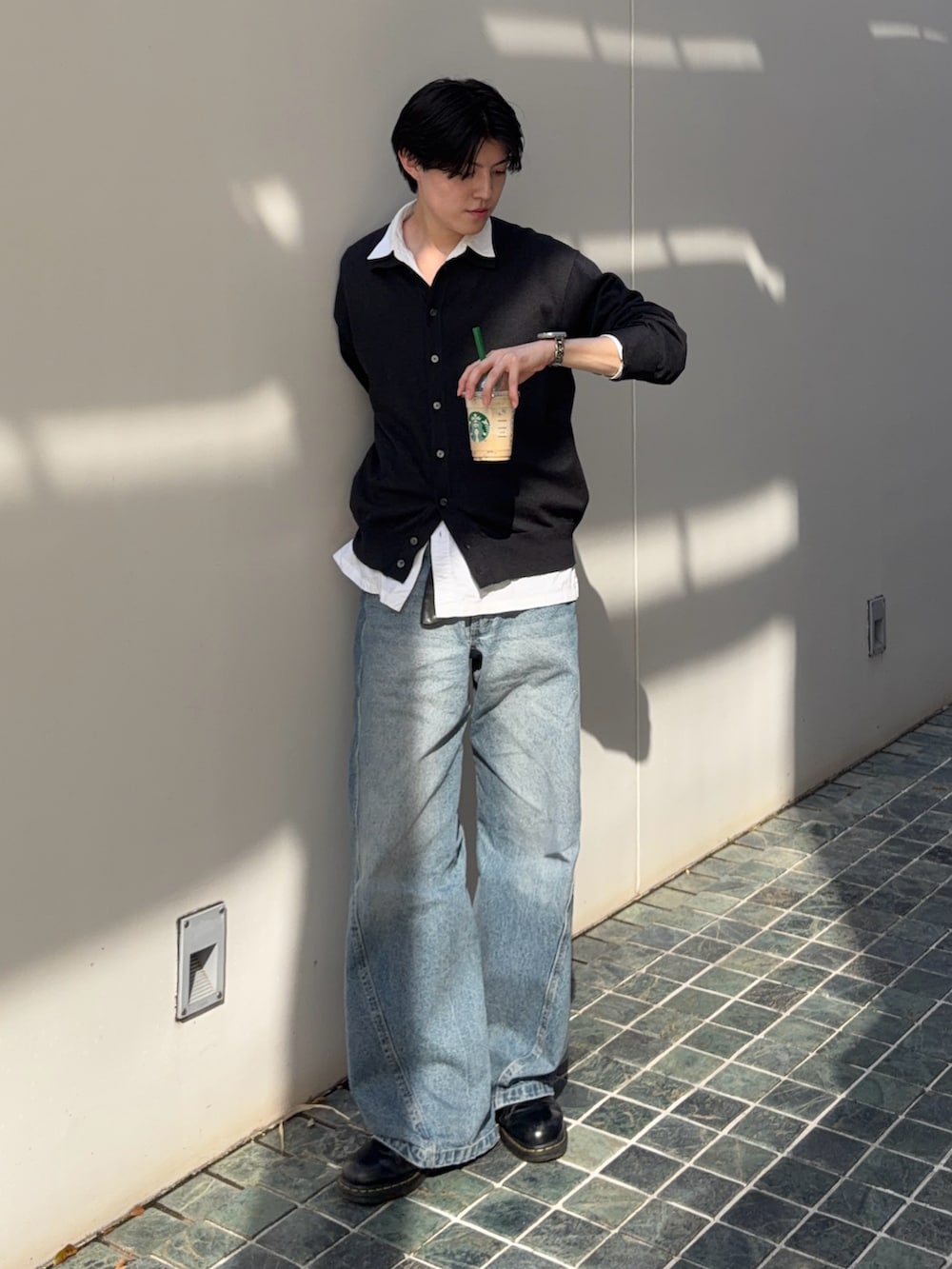ブラック系のローファー、グレー系のシャツ/ブラウス、ブルー系のデニムパンツを着用したメンズの春コーディネートの2枚目の写真