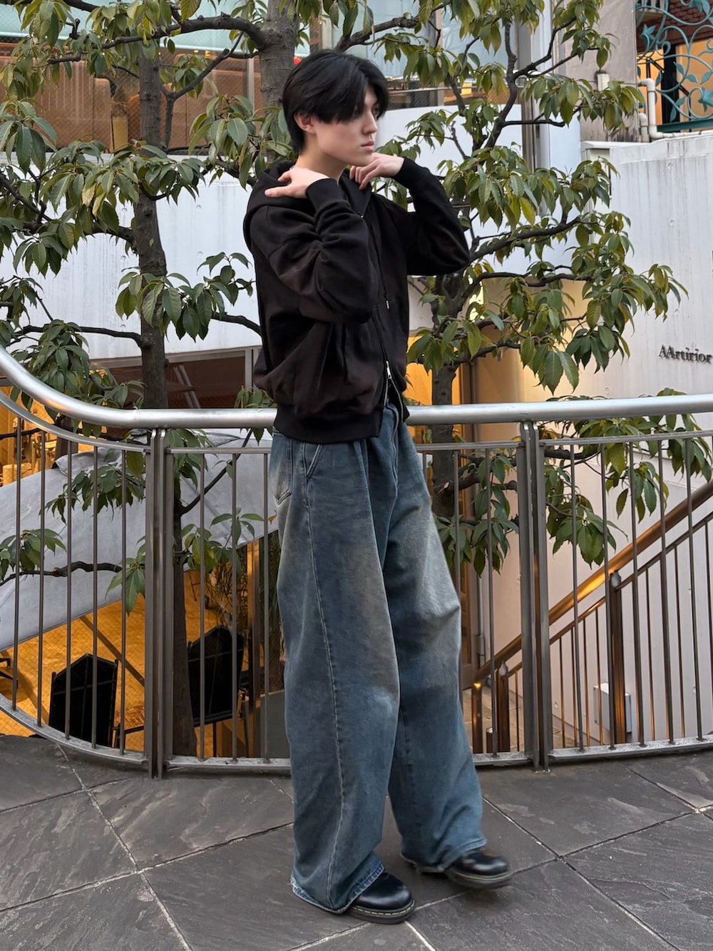 ブラック系のパーカー、ブルー系のデニムパンツ、ブラック系のローファーを着用したメンズの冬コーディネートの2枚目の写真