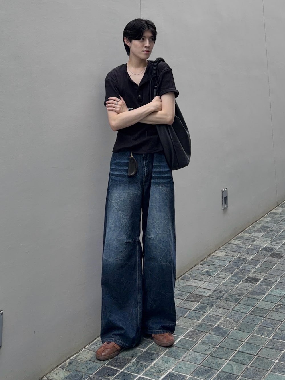 ブラウン系のスニーカー、ブラック系のTシャツ/カットソー、ブルー系のデニムパンツを着用したメンズの夏コーディネートの2枚目の写真