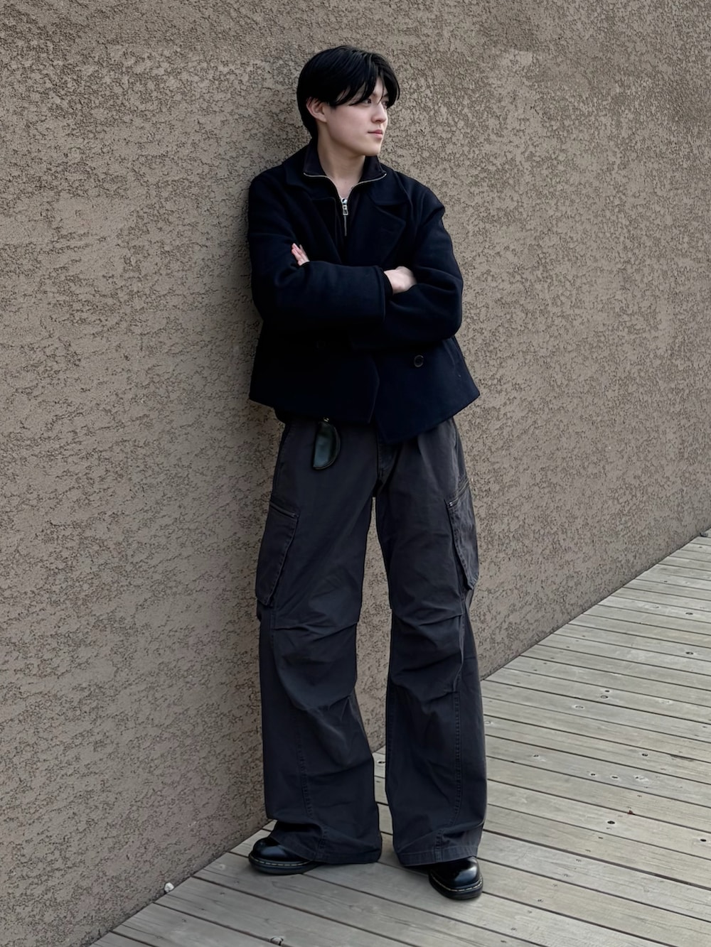 グレー系のカーゴパンツ、ブラック系のローファー、ブラック系のスウェットを着用したメンズの冬コーディネートの2枚目の写真