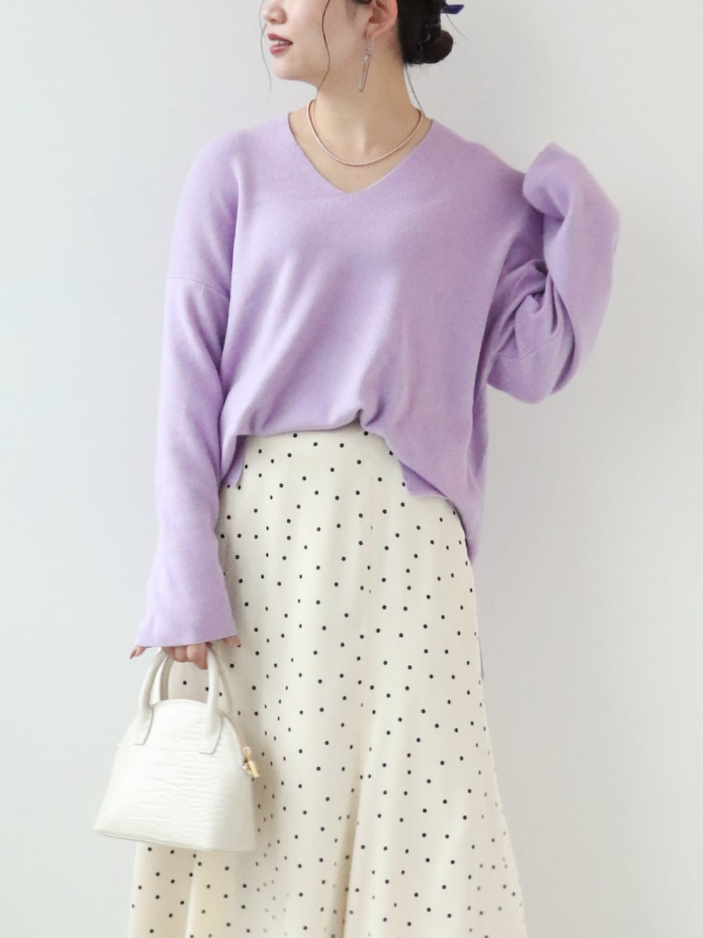 ホワイト系のショルダーバッグ、ホワイト系のスカート、パープル系のニット/セーターを着用したレディースの秋コーディネートの3枚目の写真
