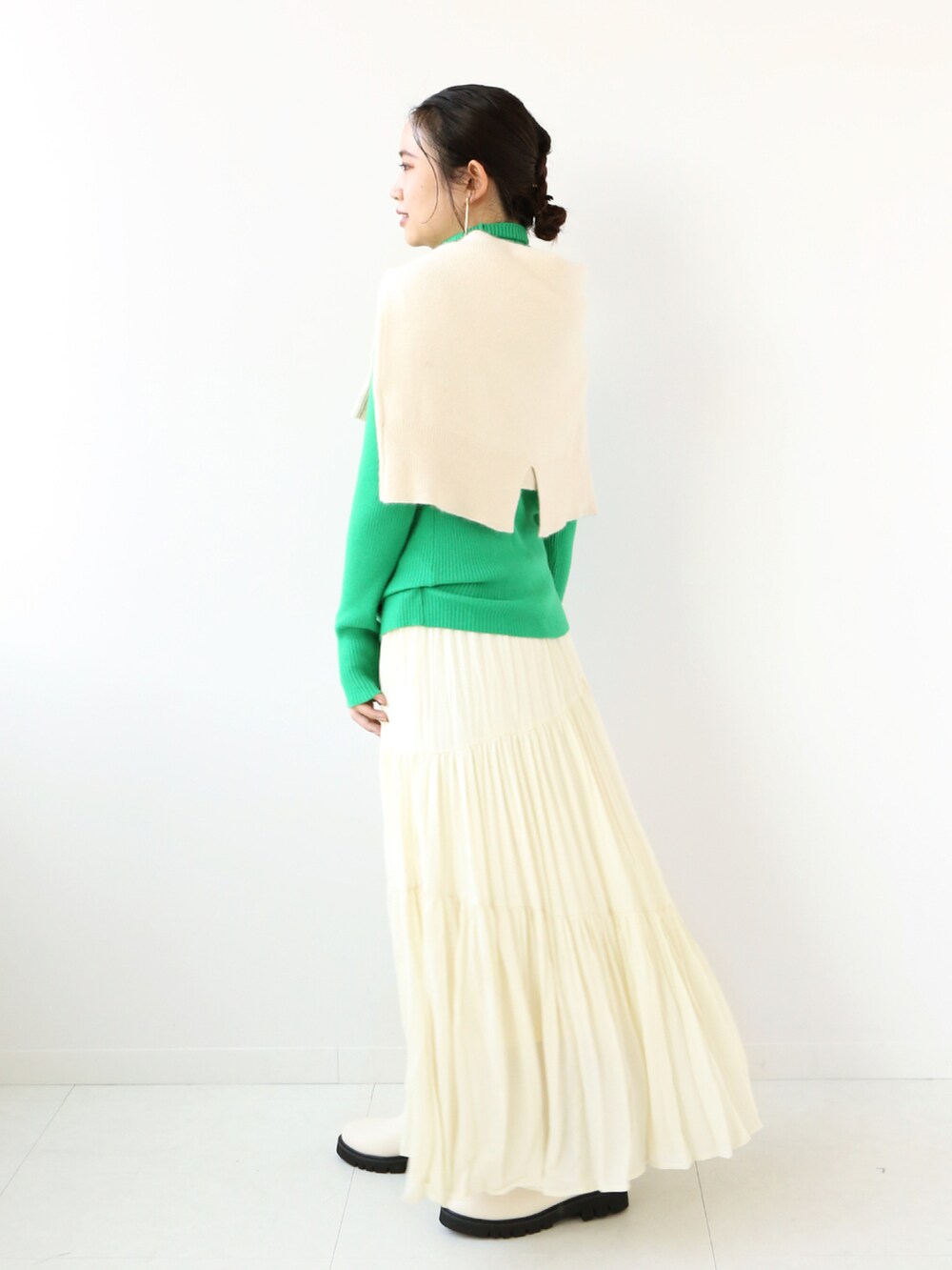 グリーン系のニット/セーター、ホワイト系のニット/セーター、ベージュ系のスカートを着用したレディースの冬コーディネートの3枚目の写真
