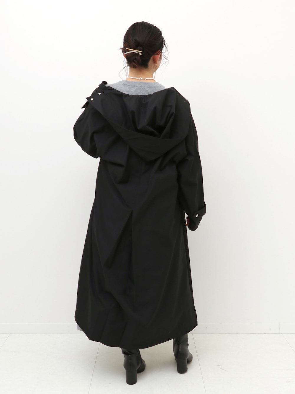 グレー系のワンピース、ブラック系のノーカラーコートを着用したレディースの冬コーディネートの5枚目の写真