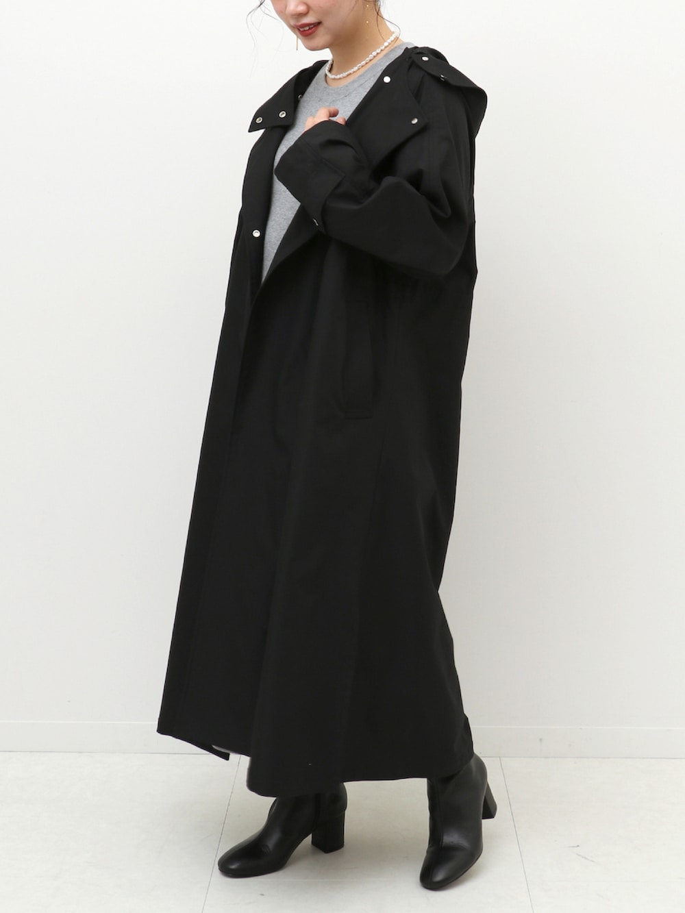 グレー系のワンピース、ブラック系のノーカラーコートを着用したレディースの冬コーディネートの4枚目の写真