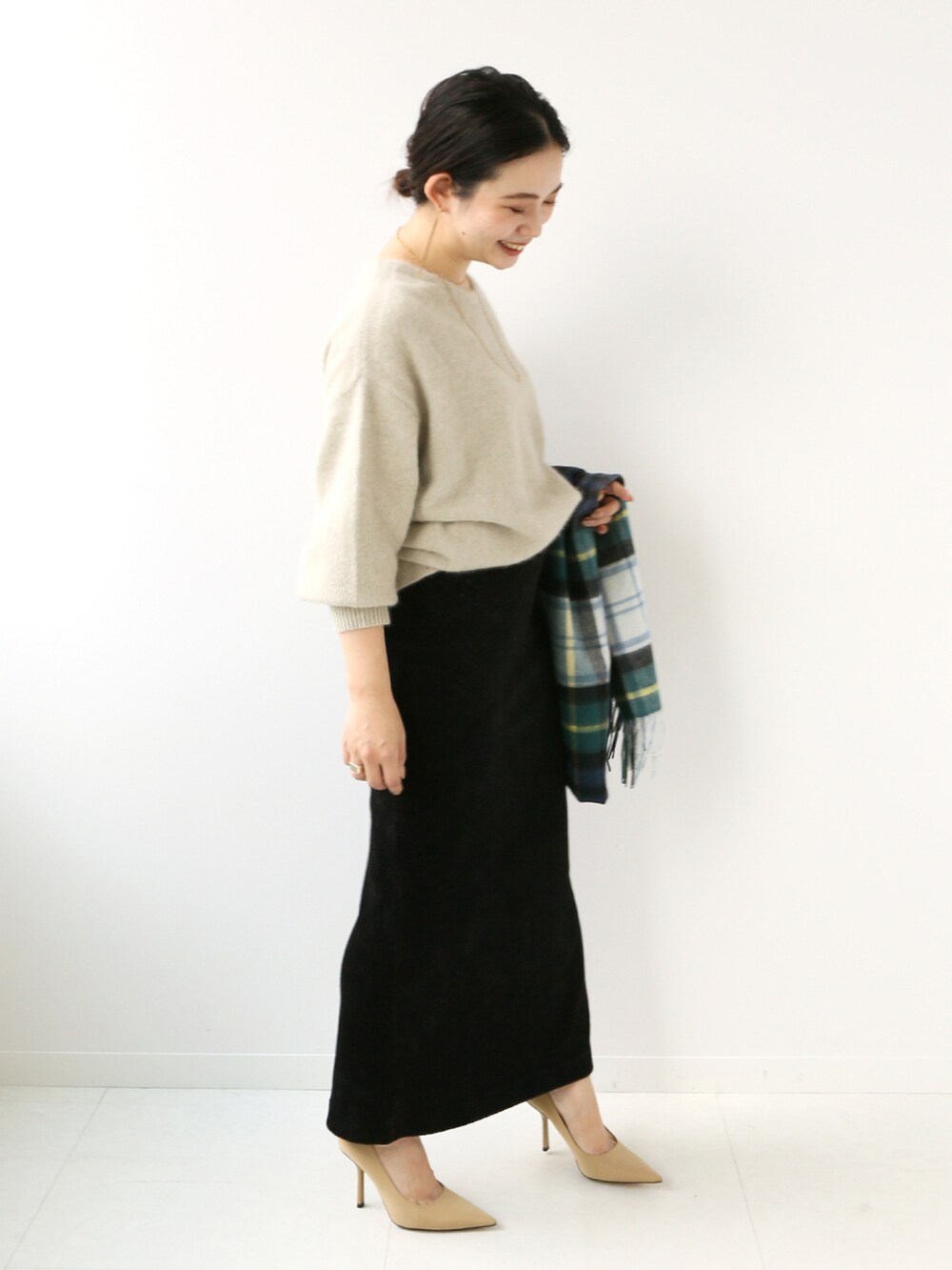 ベージュ系のニット/セーター、ブラック系のスカート、ブルー系のマフラーを着用したレディースの秋コーディネートの2枚目の写真
