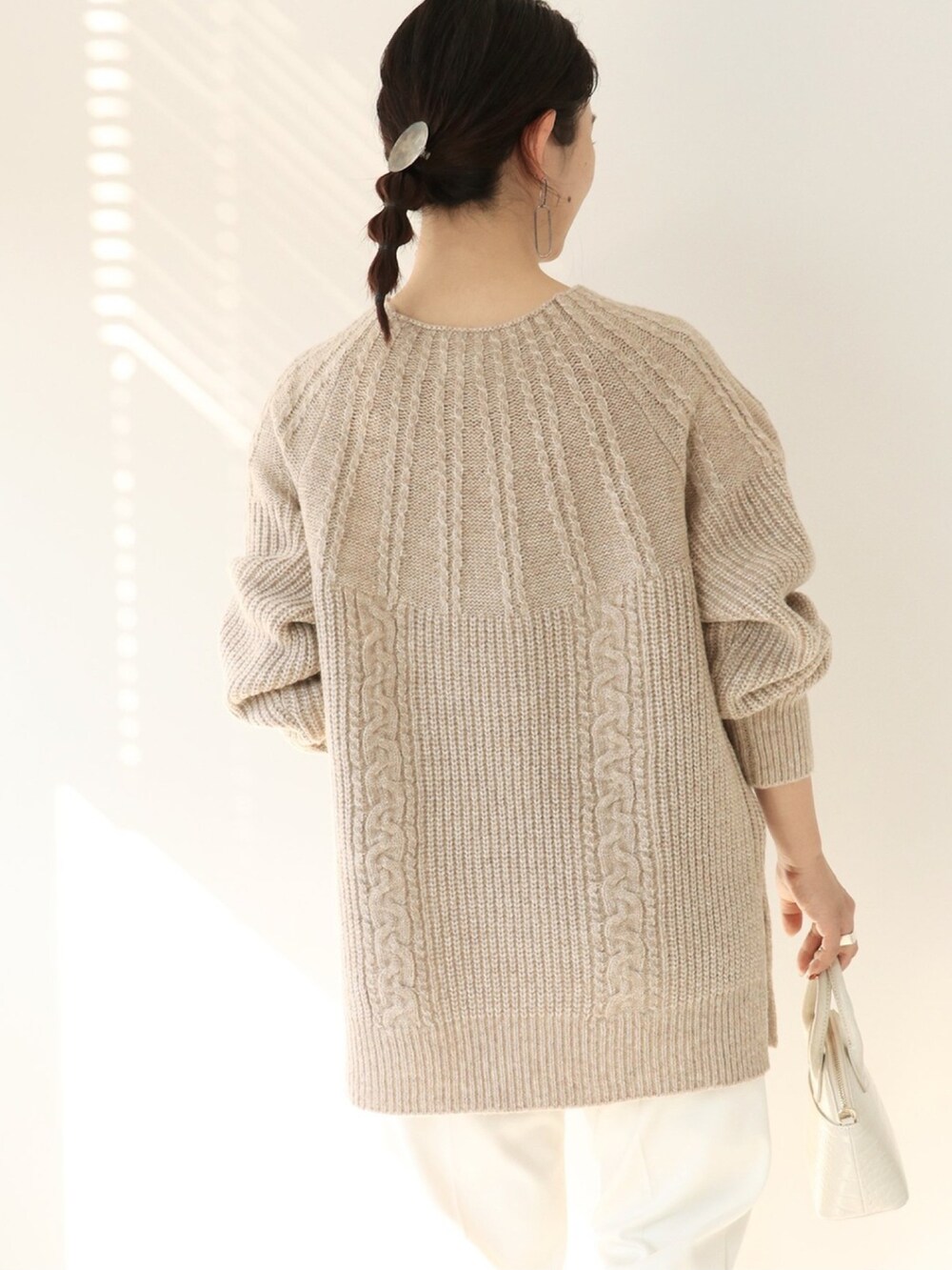 ベージュ系のニット/セーター、ホワイト系のスラックス、ホワイト系のショルダーバッグを着用したレディースの冬コーディネートの4枚目の写真