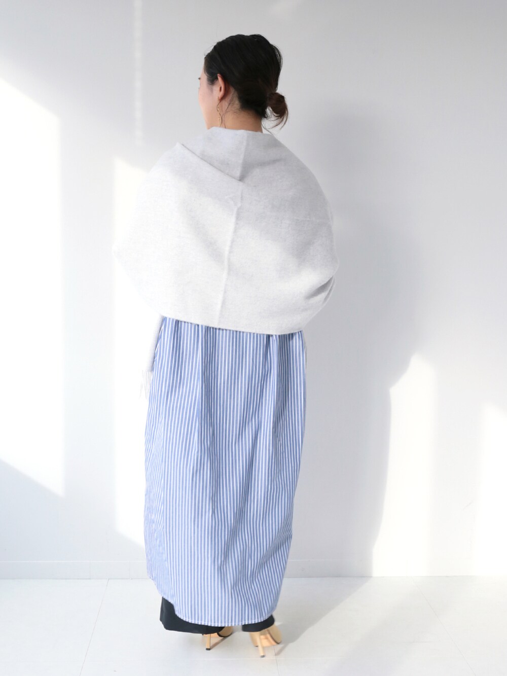 ブルー系のワンピース、ブラック系のスラックス、グレー系のマフラーを着用したレディースの冬コーディネートの3枚目の写真