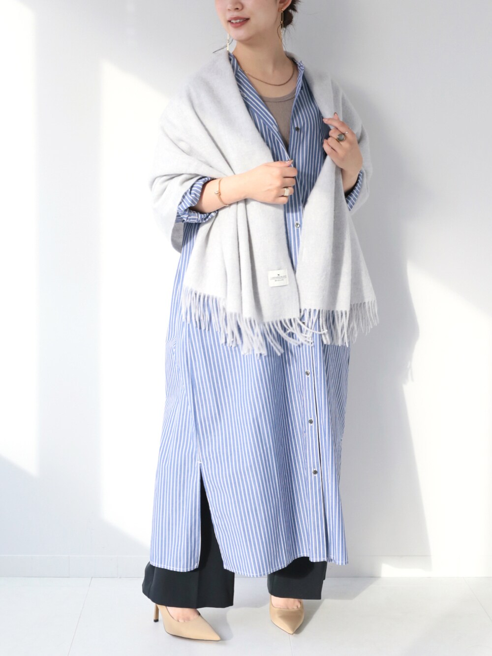 ブルー系のワンピース、ブラック系のスラックス、グレー系のマフラーを着用したレディースの冬コーディネートの4枚目の写真