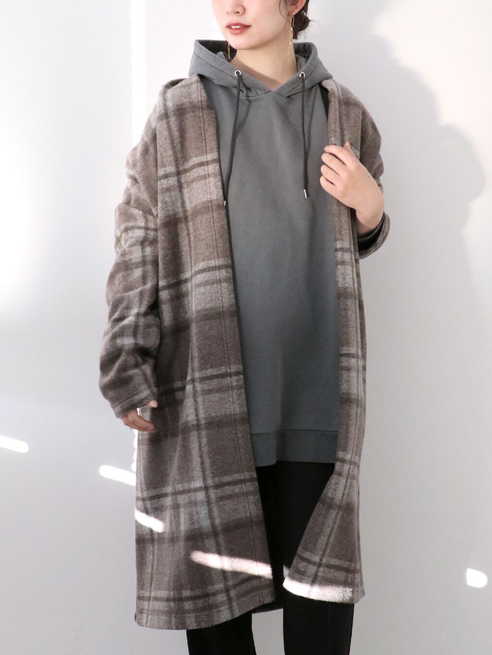 ブラック系のパーカー、ブラウン系のその他アウター、ブラック系のスラックスを着用したレディースの冬コーディネートの4枚目の写真