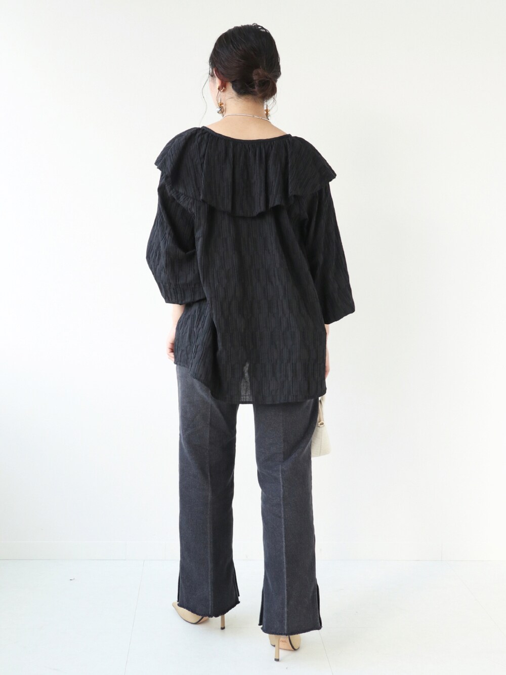 ブラック系のシャツ/ブラウス、ブラック系のデニムパンツ、ホワイト系のショルダーバッグを着用したレディースの秋コーディネートの3枚目の写真